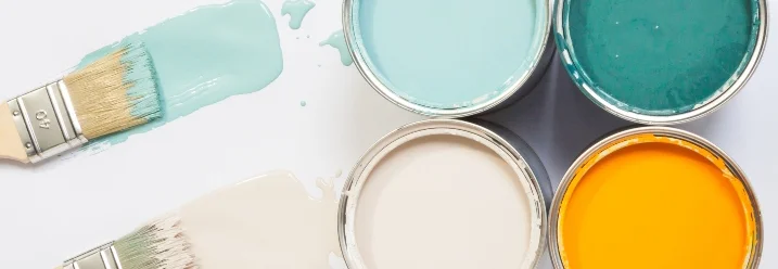 Vier Farbtöpfe und zwei Pinsel